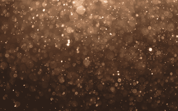Speckles of sparkling brown dots on a brown background.