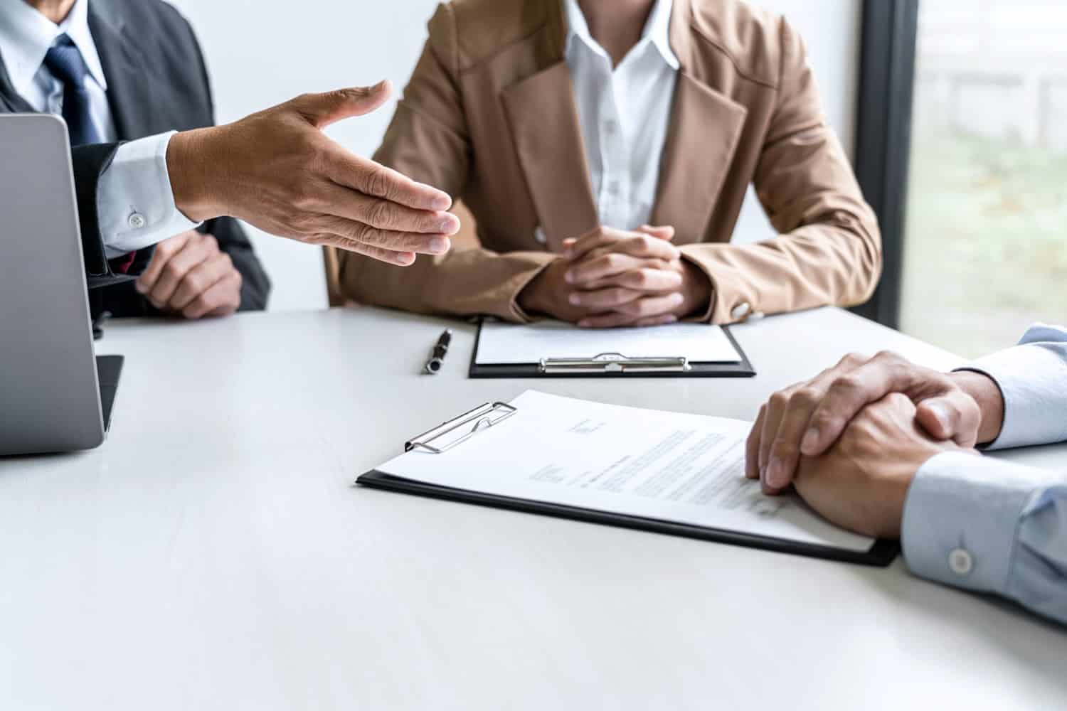 Businessperson explaining about their profile to two selection committee managers sitting in during job interview