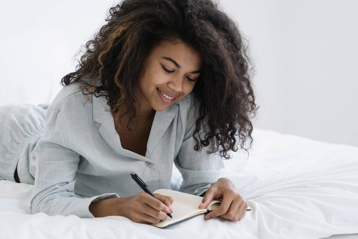 Woman journaling on bed
