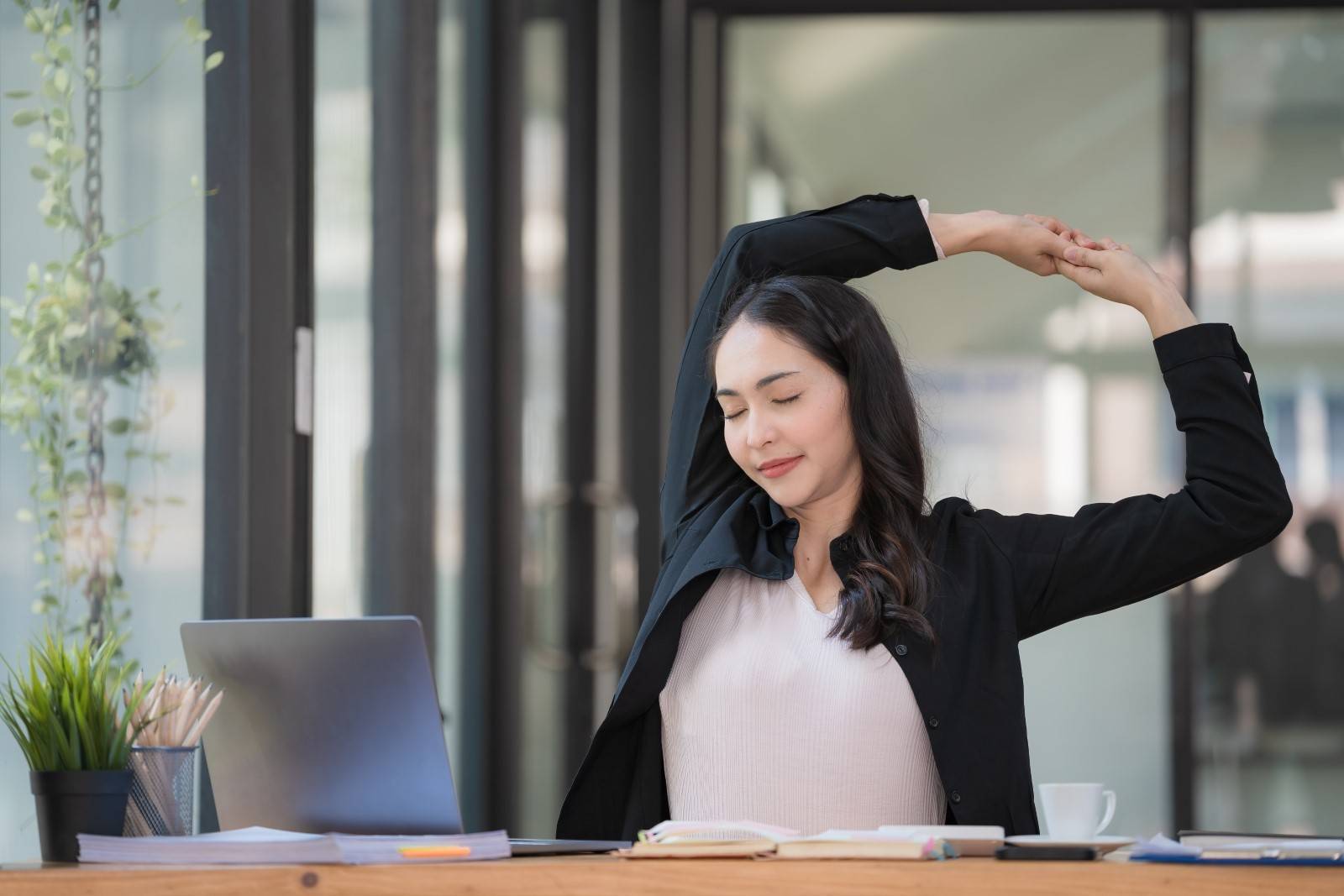 Businesswoman stretching at desk
