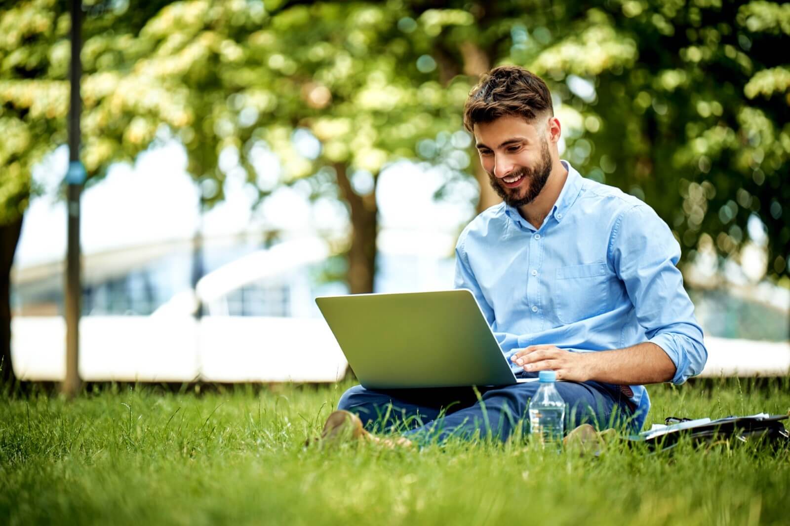 Businessman working on laptop in the park