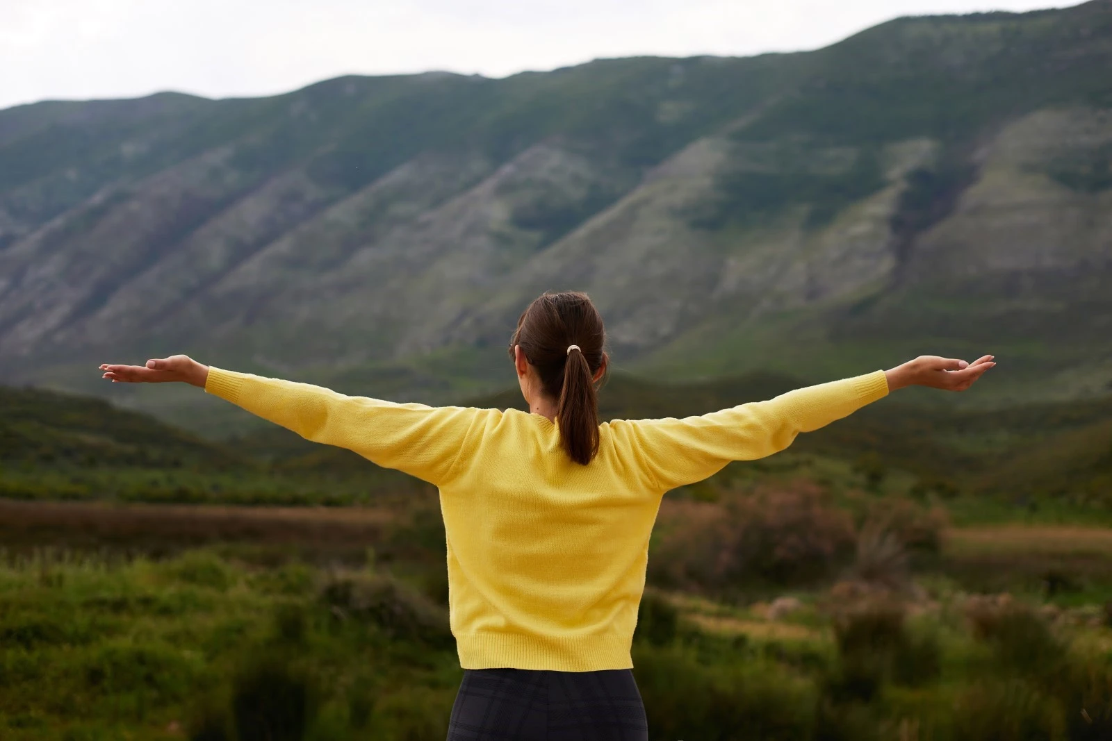 Woman raising her arms out to show resilience